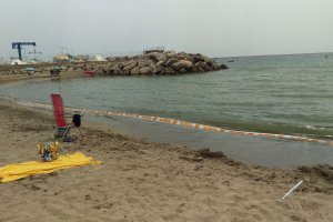 La cinta de Protección Civil acota la zona de la playa cercana al puerto.