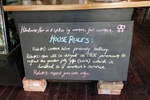 Imagen del cartel que explica las condiciones por las que el hombre debe pagar un 18% más por un café.