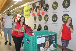Emi Rubio, técnico de juventud de Cruz Roja en Almería;?junto a Kodro y Elena, voluntarios de Cruz Roja en Almería, depositando las mochilas donadas.