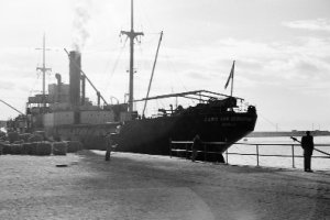 El vapor Cabo San Sebastián, atracado en el puerto de Almería en el invierno de 1955 mientras se embarcaba un cargamento de esparto hacia Barcelona.