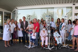 En la imagen, niños enfermos de cáncer, sus familiares, el equipo médico que les atiende y el delegado de Salud, todos con el lazo dorado en solidari