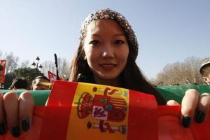 Una joven enseña una bandera de España