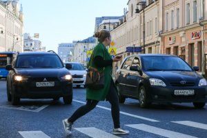 Una mujer cruza la carretera con el teléfono móvil en su mano. /Getty Images
