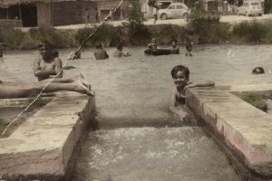 Una de las fotos de la exposición, en la que se puede ver bañistas  disfrutando en la balsa.