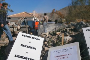 Pancartas de protesta tras una demolición de una vivienda ilegal años atrás.