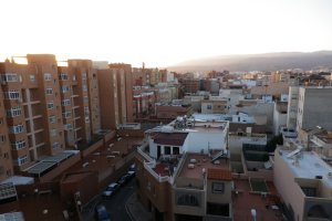 Bloques de pisos a la izquierda y casas de planta baja a la derecha. Al fondo, las montañas bajo las cuales se sitúa el casco histórico.