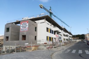 Obras de construcción del edificio en el que se puede ver el cartel para la visita al piso piloto.
