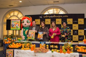 Gadorina, la mascota del Día de la Naranja, acompaña a la alcaldesa, diputada y concejales en la presentación.