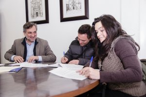 El diputado provincial firma un contrato con nuevos compradores de vivienda. L
