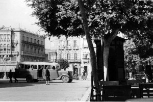 La Puerta de Purchena a finales de los cincuenta, con el autobús pasando y la gente cruzando por en medio.
