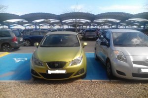 Dos vehículos estacionados en plazas de movilidad reducida.