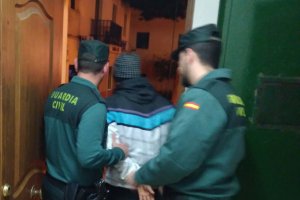 Dos agentes con el acusado, tras la detención.