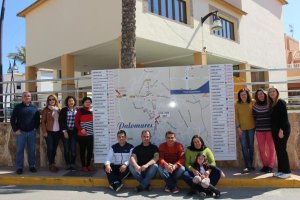 Miembros de la recién creada Asociación posan junto a una de las vallas en las que se sitúa Palomares en el mapa de la zona.