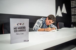 La autora de ‘Me muero por saberlo’ firmando ejemplares en la presentación. 