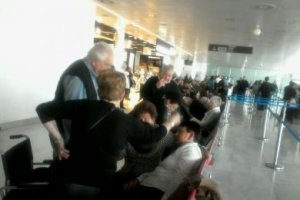 Una de las viajeras es atendida por compañeros tras sufrir un mareo en la sala de embarque.