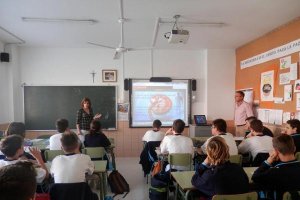 Varios alumnos de una clase recibiendo una charla-taller sobre la función y disfunción de los riñones. 