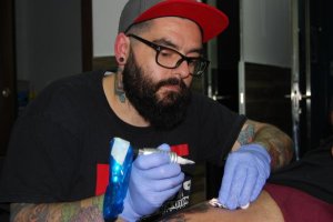 David Hernández Guerrero, Coco Guerrero en la profesión, tatúa el muslo de un cliente.