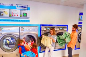 Una familia hace la colada en esta lavandería autoservicio.