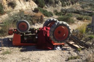 Imagen, cedida por los Bomberos del Levante, del tractor volcado que provocó la muerte del hombre que lo conducía.