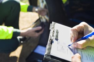 Un conductor rellena un parte de accidente.