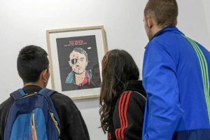 Visitantes a la muestra ‘Personajes’ viendo el retrato de De Niro en ‘Taxi Driver’. 