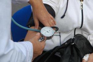 Una sanitaria toma la tensión a un paciente.