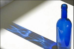 La sombra de la botella es alargada.