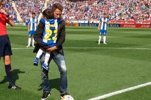 Tamudo realizando el saque de honor con su hijo en brazos.