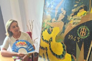 Aurora Carretero, la directora de la sección de Archivos y Bibliotecas del Ayuntamiento, con un abanico del 99 y un cartel de Feria del 43.