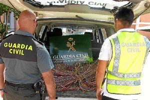 Agentes observan el material localizado al detenido.