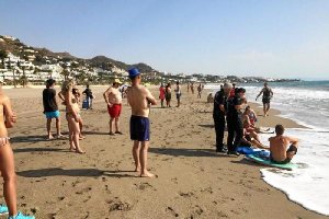 La Policía junto a los bañistas tras ser rescatados. 