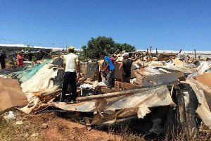 Algunas de las personas desalojadas, buscando entre los restos de las chabolas.