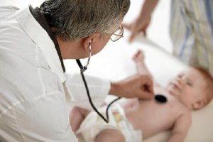 Un médico pediatra reconoce a un bebé en la consulta.