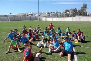 Los alumnos atienden al profesor Rubén Gallardo sobre el césped.
