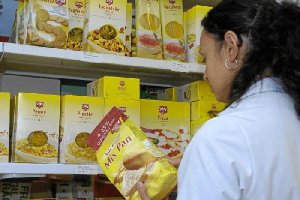 Una mujer lee la etiqueta de un producto con harina para conocer si lleva o no gluten. 