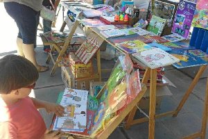 Un niño lee un libro en el espacio que Librería Zebras desplegó ayer en el Parque de las Familias, donde exhibió literatura infantil y también juveni