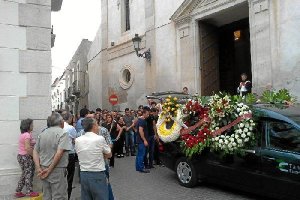 Los hijos  y amigos esperan para sacar el féretro.