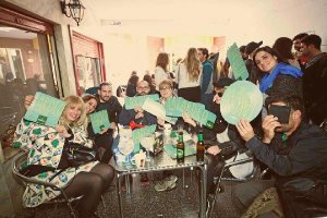 Los Clientes de la Cafetería Alhambra muestran carteles con la palabra Tardeo, una iniciativa de la asociación. 