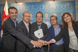 Los firmantes del convenio unen sus manos 