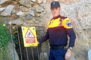 Agente de Protección Civil, junto a un pozo señalizado.