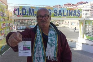 Con el carné del Betis y la bufanda verdiblanca.