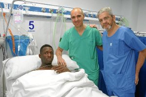 El jugador del Granada con los doctores tras la operación.