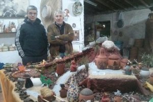 Antonio y Juan Alfonso posan junto al belén que han creado utilizando utensilios tradicionales