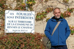 Óscar Fábrega, junto al cartel de Rennes-le-Château, en Francia, en el que se prohíbe excavar. 