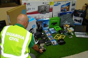 Un agente junto a material incautado a los detenidos.