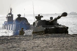 Un embarcación de asalto transporta artillería autopropulsada en la playa de Quitapellejos