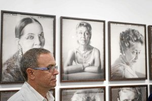 Chema Conesa, frente a algunos de los retratos que muestra en Almería.