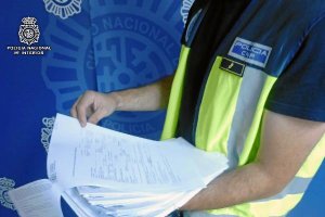 agentes de la Policía Nacional muestra documentación aprehendida