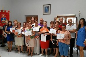 Las participantes en el curso muestran el diploma acreditativo.