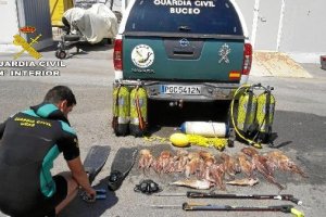 Un agente junto a los pulpos que habían pescado ilegalmente.